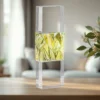 Clear rectangular glass block mounted on a metal frame, with a yellow-green faceted interior, on a wooden table